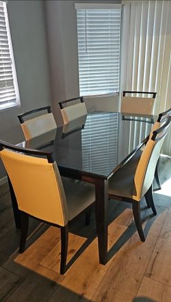 Modern espresso wood dining table with six upholstered chairs.