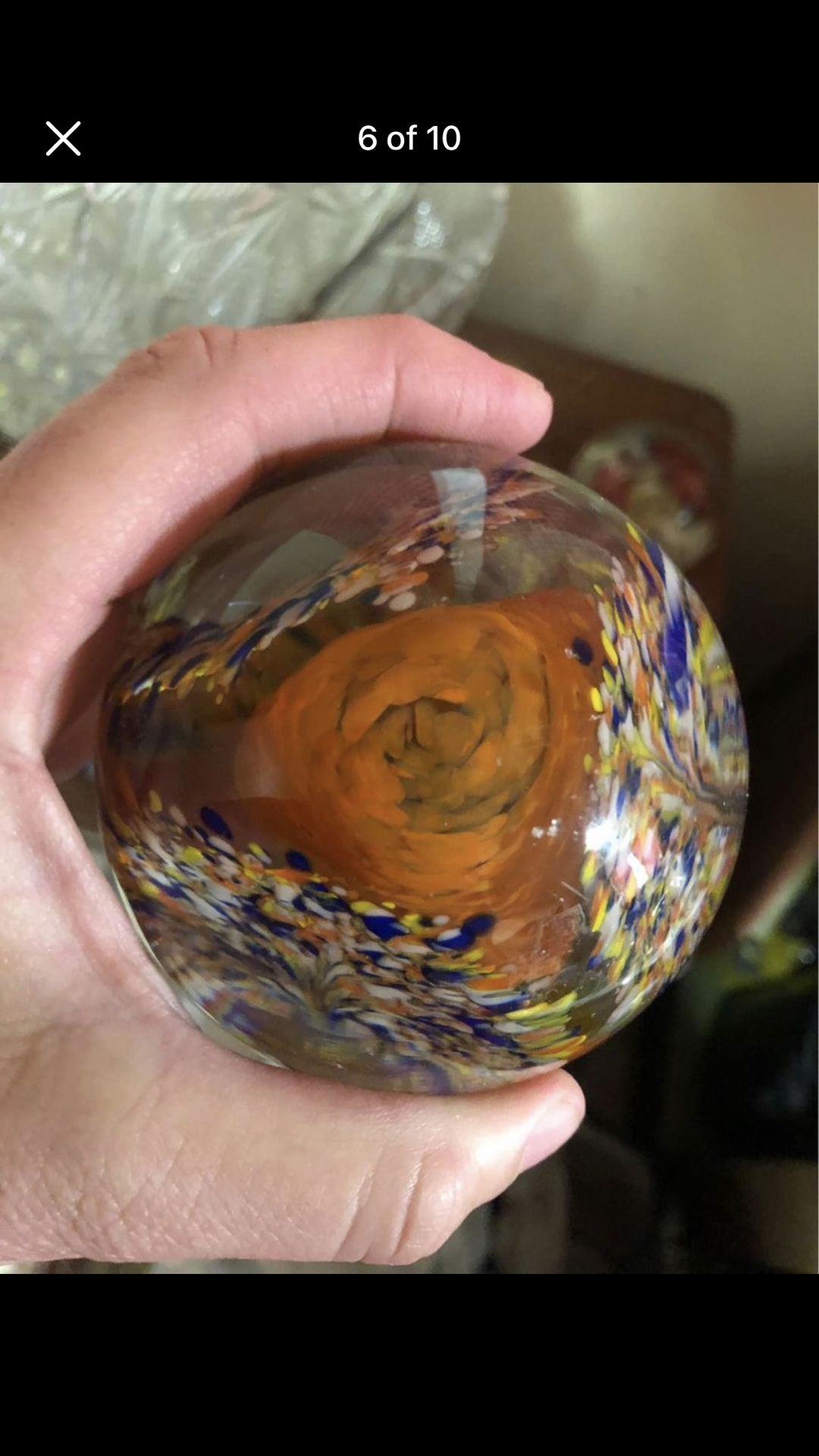 Vintage clear glass paperweight with orange flower and colorful glass surrounding it