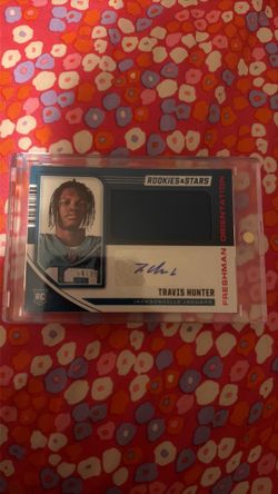 2025 Panini Rookies & Stars Travis Hunter Freshman Orientation rookie autograph card featuring a jersey swatch
