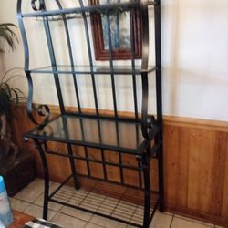 Beautiful Glass and metal baker's rack/wine rack. 3 glass shelves no chips or cracks. Can hold 6 bottles of wine and 4 rows of glasses about 12 total.