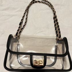 Clear stadium bag with black and gold braided strap and gold hardware