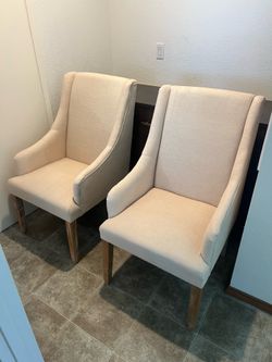 Pair of neutral upholstered wingback chairs