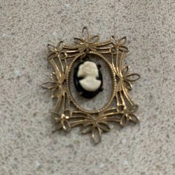 vintage gold-tone filigree cameo pendant featuring a carved profile of a woman, which can also be worn as a brooch