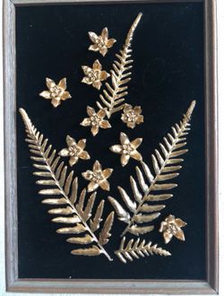 Framed Hawaiian flowers that are plated with gold