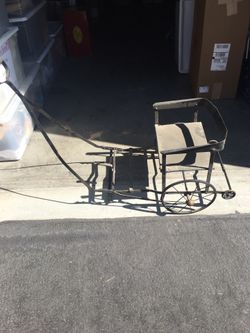 Vintage or antique doll carriage. Black iron with leather (?)