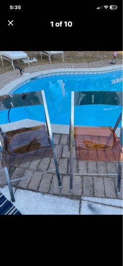 Pair of 2 tea colored lucite folding chairs with chrome .