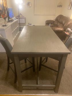 Gray dining room table with two chairs