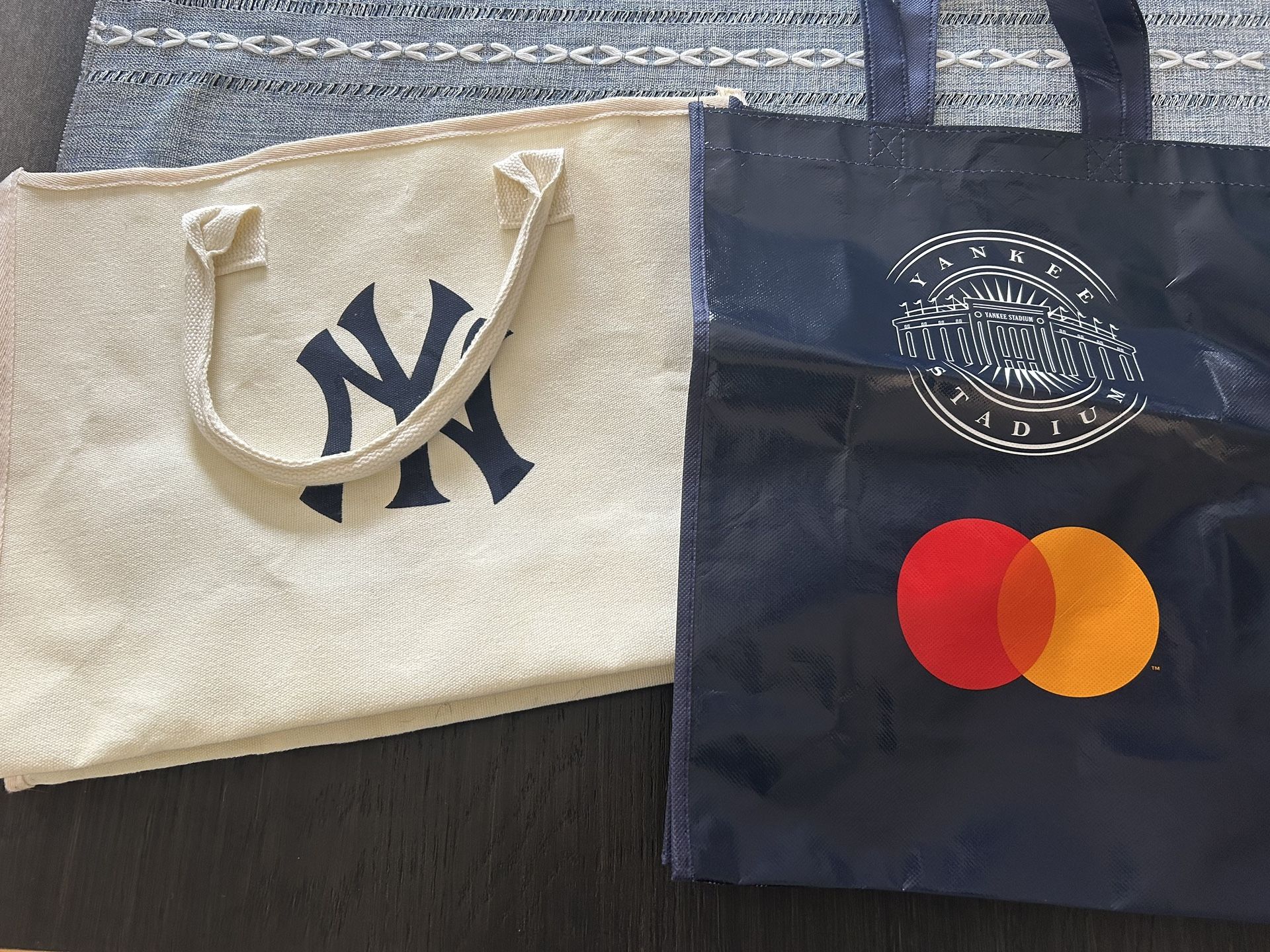 Navy and white Yankees tote bags from games at Yankee Stadium