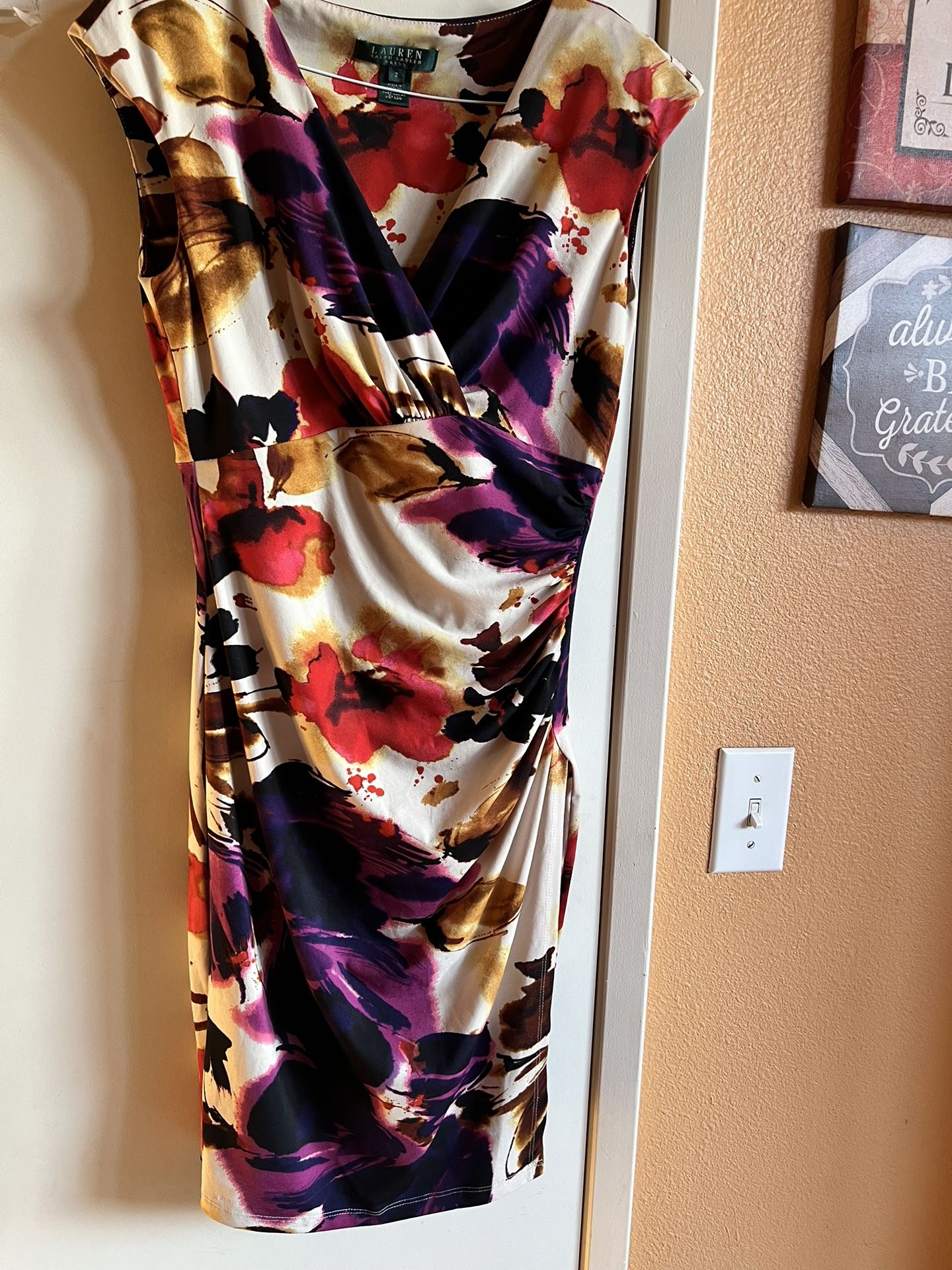 Ralph Lauren Chic asymmetrical dress with bold floral patterns. Features vibrant red and purple hues. Ideal for stylish outings. New no tags. Size 2.