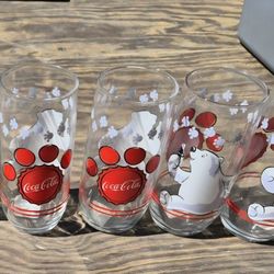 1999 Anchor Hocking Coca-Cola polar bear paw print drinking glass featuring red "Coca-Cola" branding. 2000 green glass Coca Cola 