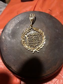 14 kt Cadillac pendant.