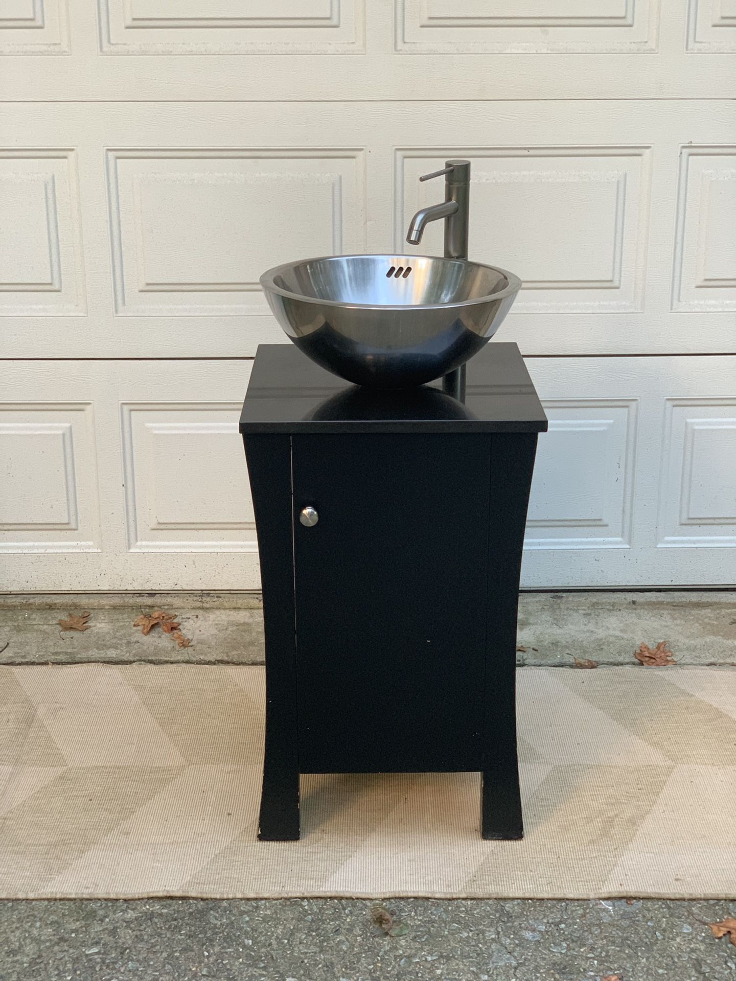 Contemporary double-wall stainless steel vessel sink with a dark brown wooden vanity