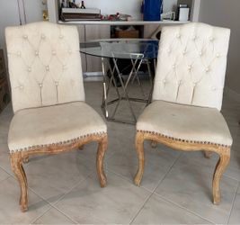 Two upholstered cream dining room chairs