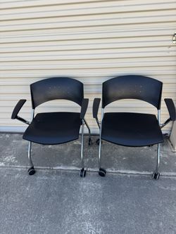 2 Nesting chair with casters. Black plastic back and seat with chrome frame.