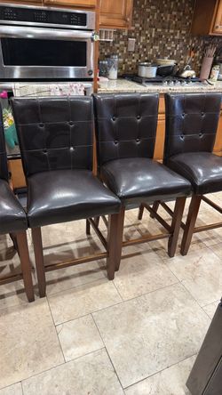 8 counter high chairs brown fox leather material  Some has button missing one chair has broken back piece as seen in last picture and little ripped on