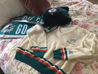 Miami Dolphins sweater, fan banners, pillow, fabric, and glass