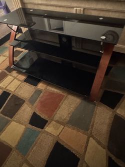Black glass TV stand in good used condition. $100. Pickup only.