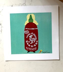 Skylar Tharp Sriracha Art Print - 8” x 8” (Art image is 6 x 6)   Whimsical art print. This piece features a red Sriracha bottle with blonde hair and a