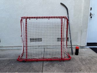 Goal, hockey stick, and 8 pucks
