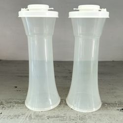  Tupperware hourglass salt and pepper shakers. Unused.  Clear body with white lids. These are the large size at 6 1/4” tall. 