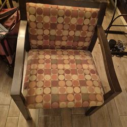 wood-framed accent armchair with a patterned fabric seat and back cushion. 
