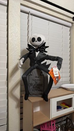 Jack skelington sitting on grave.