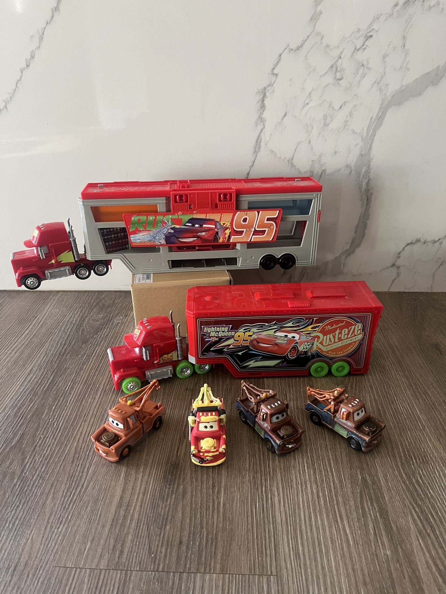 Disney and Pixar Cars toys, primarily featuring Mack haulers and Mater vehicles.