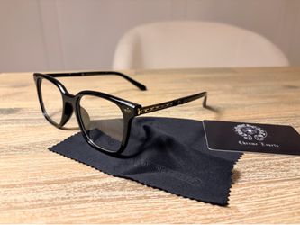 Black chrome hearts glasses with gold highlights.