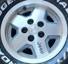 Jeep Stock Rims 5Lug set of 4 weels
15x7 OEM 5-spoke aluminum alloy "Jeep" logo wheel (part number 8) from a late-1980s to mid-1990s Jeep