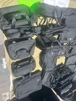 Many Tumi messenger bags and rolling briefcases
