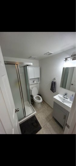 Vanity, facet, mirror, light fixtures and white medicine cabinet