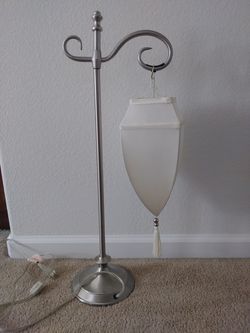 Nice lamp silver with cream fabric shade. 28 inches tall.