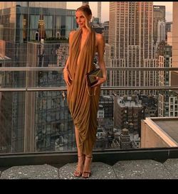 elegant brown draped halterneck dress featuring a soft, fluid cowl neckline and asymmetric gathering