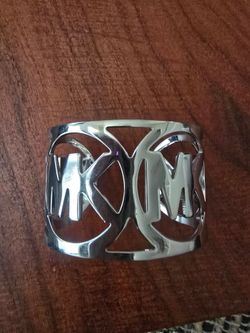 VINTAGE and Polished silver-tone cuff bangle bracelet with cutout initials forming a logo. Bold and modern design. Sleek reflective finish. Easy to st