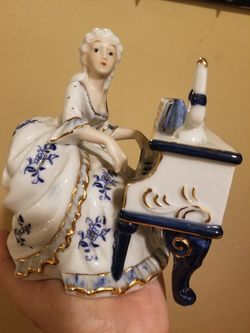 Very nice handmade art doll playing the piano .