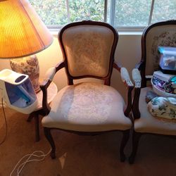 Two matching reproduction armchairs (not antiques/vintage originals).
Dark wood frames with carved details, curved arms, cabriole legs.
Upholstered in