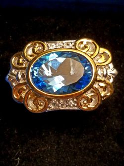 GORGEOUS BLUE TOPAZ AND DIAMOND RING SET IN 925 STERLING SILVER AND 14K YELLOW GOLD. SIZE 8,