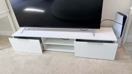 Modern white TV stand with two drawers and open shelves.