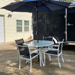 New, Riverbrook Shell White 48-inch Round Glass Top Outdoor Patio Table, 4 Marivaux Black and White Steel Outdoor Stacking Sling Chairs and Blue, Thre