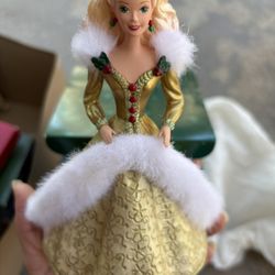 Christmas stocking hangar Barbie doll in a gold gown with white fur trim.