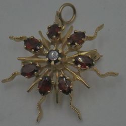 14kt yellow gold pin/pendant with garnet stones total weight 8.3 gr pre owned . 7 oval and 1 round garnet stones. 821296-1. 