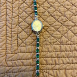 Emerald green stone tennis bracelet watch with oval face