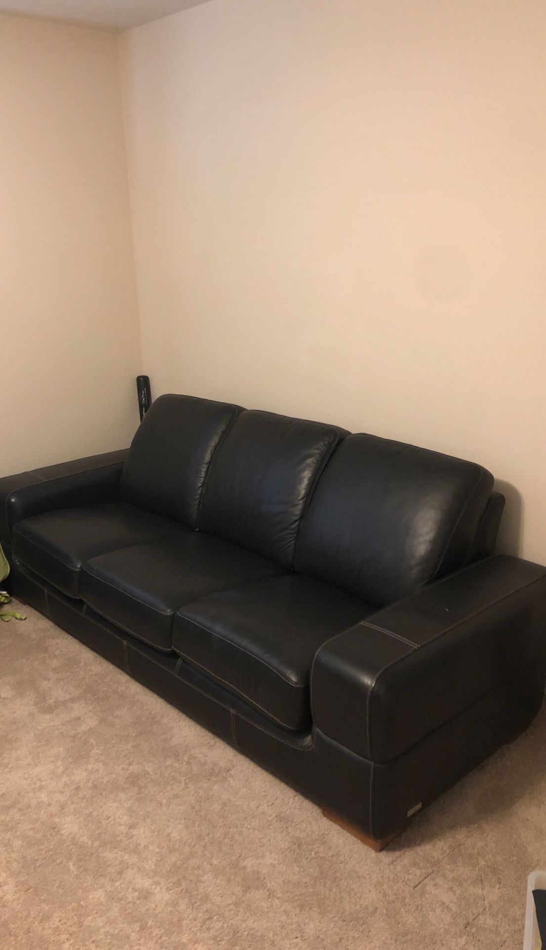 Awesome black leather couch with white cross stitch