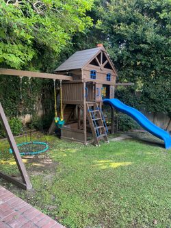 Outdoor play structure for kids with swings and slides