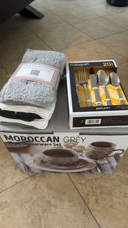 Dinnerware set with dishwashing towels and silver utensils.