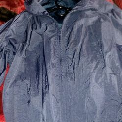 Vintage Solid blue windbreaker with rain hoodie stored on neck line 