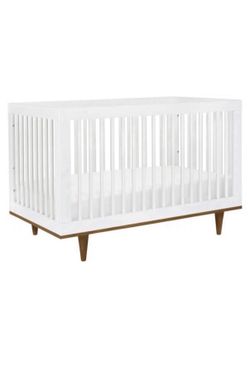 White wooden crib with brown legs