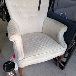 Vintage-style upholstered accent chair with a high, slightly flared back and classic rolled arms