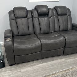 Reclining loveseat with cupholders and storage in the armrest has LED lights and chargers for phones