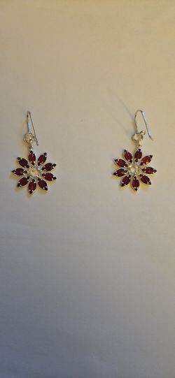 The earrings feature marquise-cut red garnets arranged around a central white stone. 